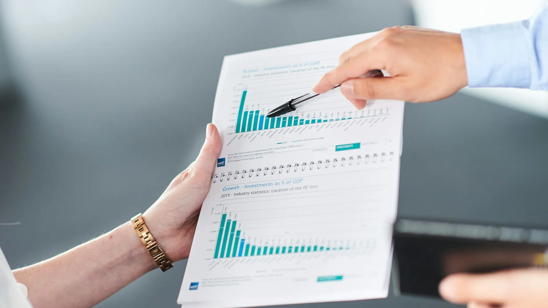 Finance professionals reviewing a management report with bar charts